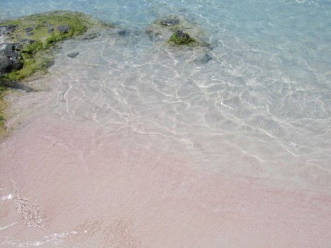 Kristallklart vatten och ljusrosa sand.
